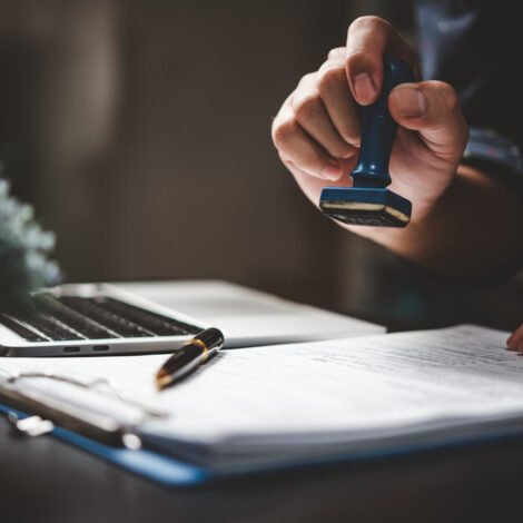 Man stamping approval of work finance banking or investment marketing documents on desk.